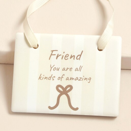 Close-up of Friend quote ceramic hanging plaque with bow motif