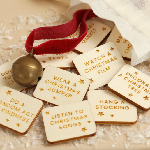 Detailed view of wooden Christmas countdown tokens engraved with holiday activities