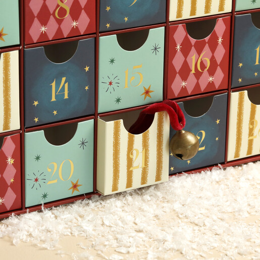 Fabric pouch of wooden Christmas tokens placed inside an advent calendar drawer