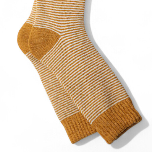 Close up of gold and cream striped knit women's cosy socks