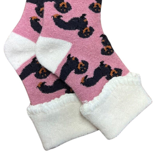 Close-up of pink sausage dog socks showing the cosy white fluffy cuffs