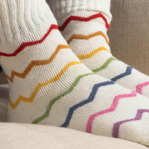 Close-up of cream cosy knit socks featuring multicoloured chevron stripes