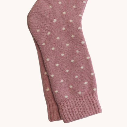 Close up of pink wool blend socks showing white fleck pattern and ribbed cuff