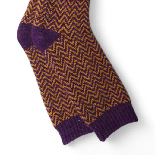 Close-up of purple and mustard yellow herringbone pattern knit men's socks