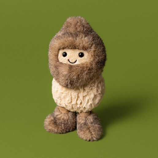 Standing Jellycat peanut soft toy dressed in a furry yeti disguise against green backdrop