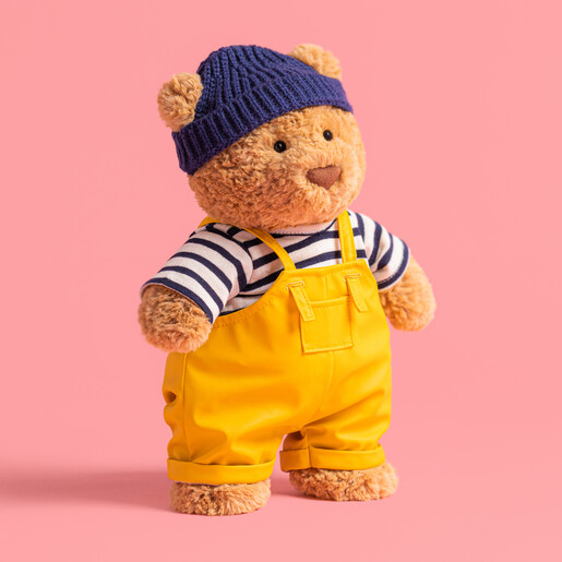 Plush Bear Dressed in Fisherman Outfit Standing Against Pink Background