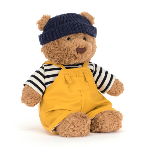 A Cuddly Plush Bear in Yellow Overalls Wearing a Navy Hat and Striped Fisherman Top in a Seafarer Style
