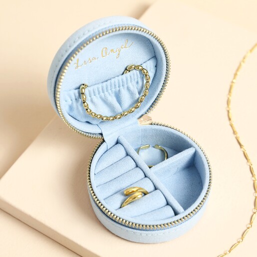 Open blue travel jewellery case showing ring rolls and compartments with jewellery