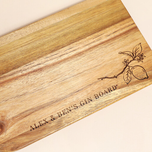 Close-up of engraved lemon branch and text on wooden G&T board