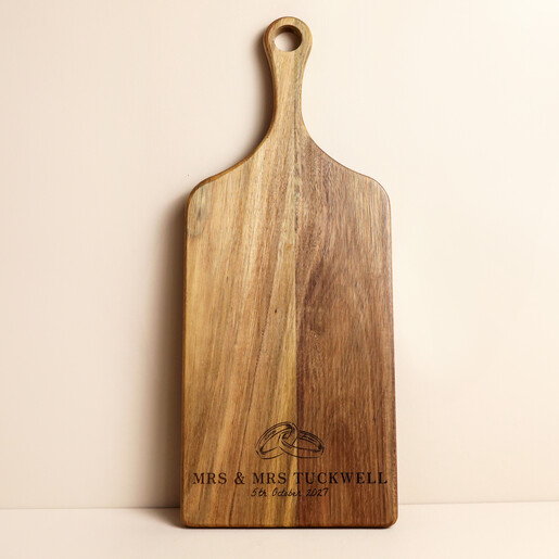 Acacia wood paddle board engraved with intertwined wedding rings and personalised names