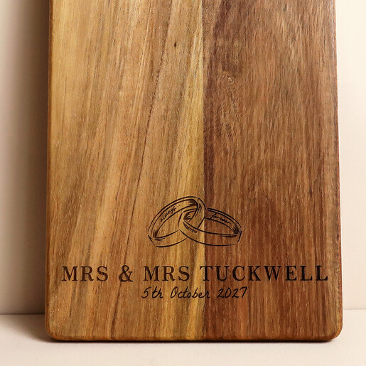 Close up of engraved wedding rings illustration and personalised couple names on wood