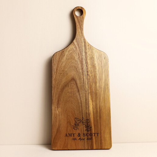 Personalised wooden paddle board engraved with celebratory champagne glasses illustration
