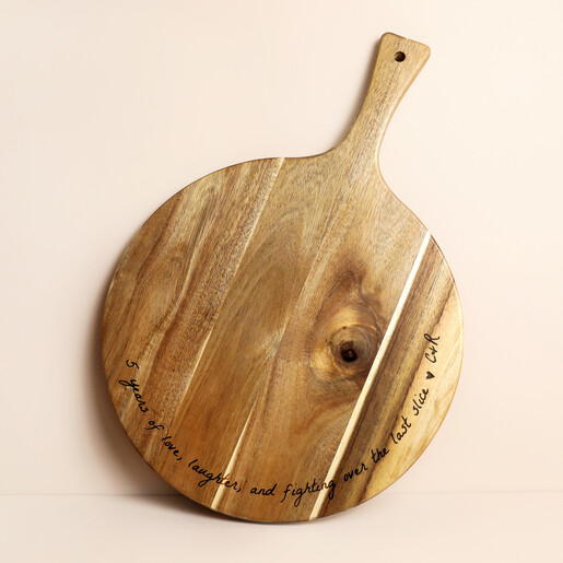 Personalised round wooden anniversary serving board against a pale neutral background
