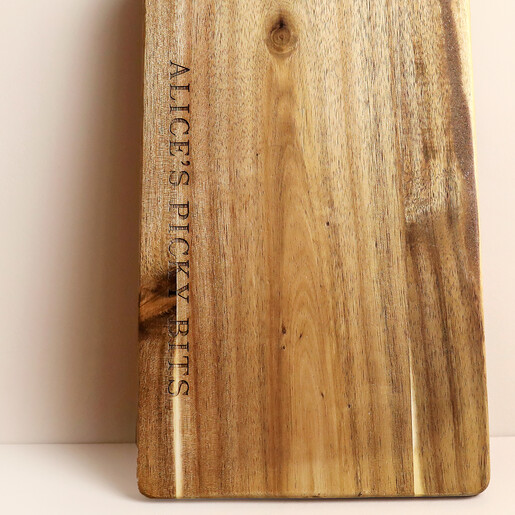 Close-up of engraved text Alice's Picky Bits on wooden serving board