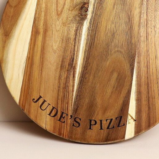 Close-up of laser engraved text on the acacia wood pizza board