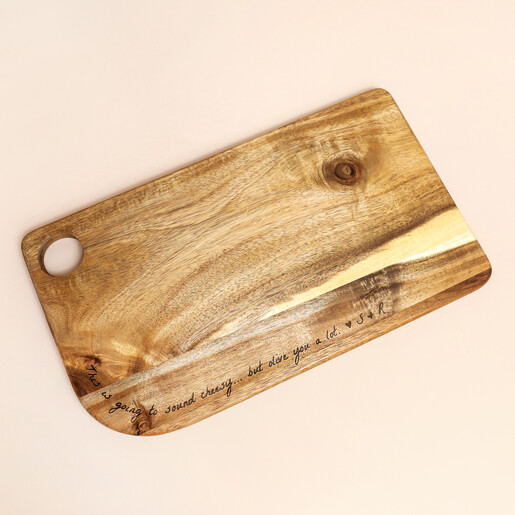 Engraved acacia wooden serving board showing handle cutout against a neutral background