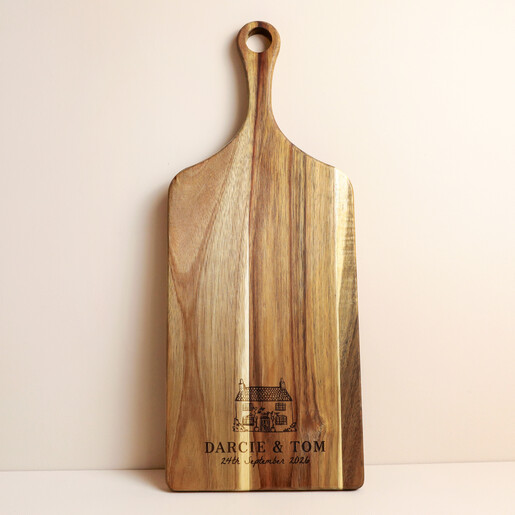 Acacia wood paddle board engraved with a cottage illustration and custom names and date