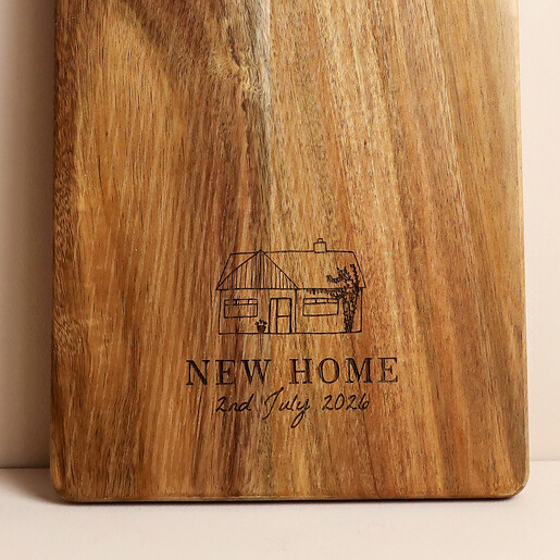 Close-up of engraved bungalow illustration and script text on natural wood grain