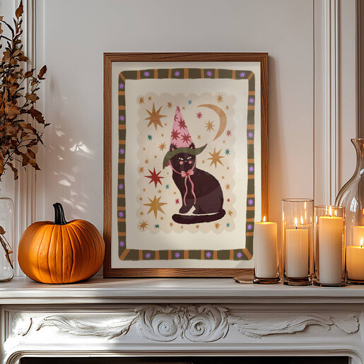 Black cat art print on a mantelpiece with pumpkins and candles