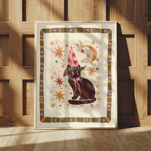 Framed black cat celestial art print leaning against wood panelling