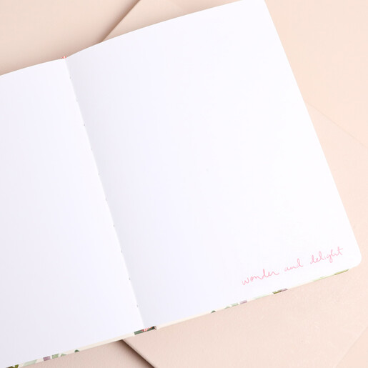 Open blank pages inside Quiet Moments sketchbook with wonder and delight prompt