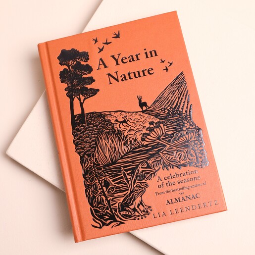 Terracotta orange A Year in Nature hardback book with black linocut illustration.