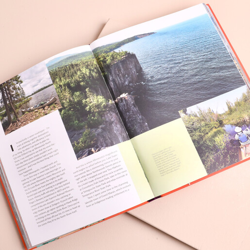 Open spread of Lonely Planet travel book showing scenic cliff and lake photography