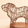 Close up of metal wire dog sculpture wrapped with fairy lights