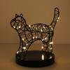 Lit black wire cat table light illuminated with warm glowing fairy lights