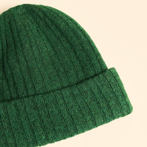 Close-up view of the rich forest green ribbed knit texture and fold-over cuff