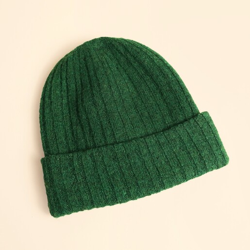 Forest green ribbed knit beanie hat laid flat on a neutral background