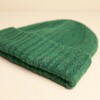 Folded brim edge of the forest green ribbed beanie hat