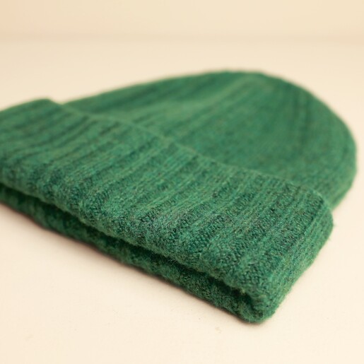 Folded brim edge of the forest green ribbed beanie hat