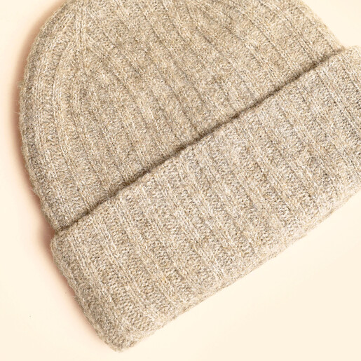 Close-up of the ribbed knit texture on the neutral beanie hat