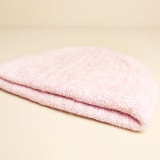 Close up of folded light pink ribbed knit beanie hat
