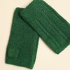 Close-up of forest green knitted fingerless gloves showing ribbing texture