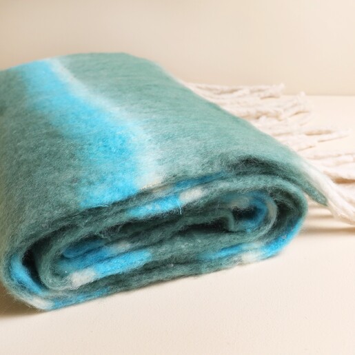 Close up of fluffy brushed green and turquoise striped winter scarf