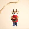 Felt reindeer hanging decoration suspended from a rustic wooden branch