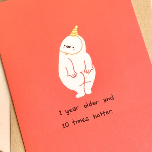 Close-up of cheeky cartoon character and witty birthday quote on red card