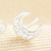 Close up of a sterling silver cubic zirconia crescent moon stud earring.