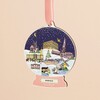 Close-up of wooden snow globe hanging decoration featuring illustrated Norfolk landmarks.