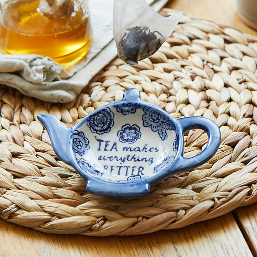 Teapot-shaped ceramic tea bag dish with blue floral details and quote