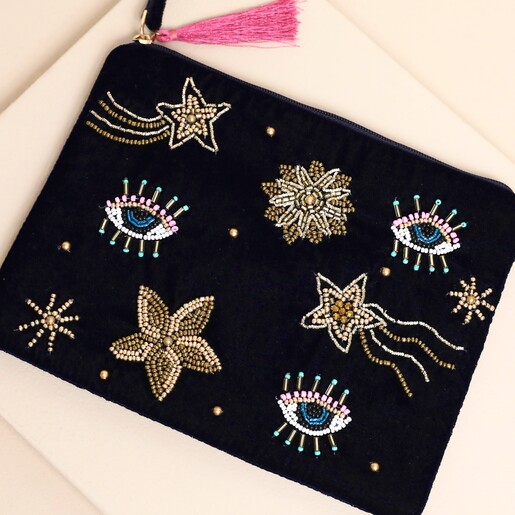 Close-up of navy velvet pouch featuring colourful beaded eyes and shooting star details.