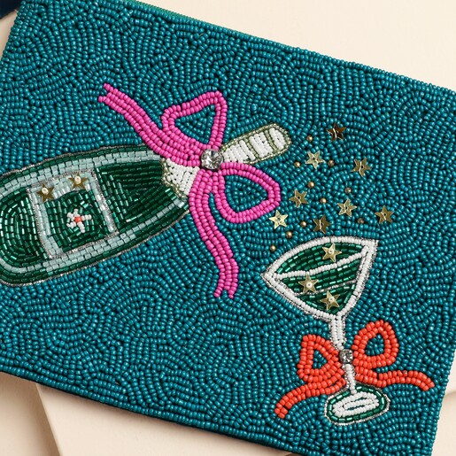 Close up of beaded champagne bottle and cocktail coupe detail on green pouch