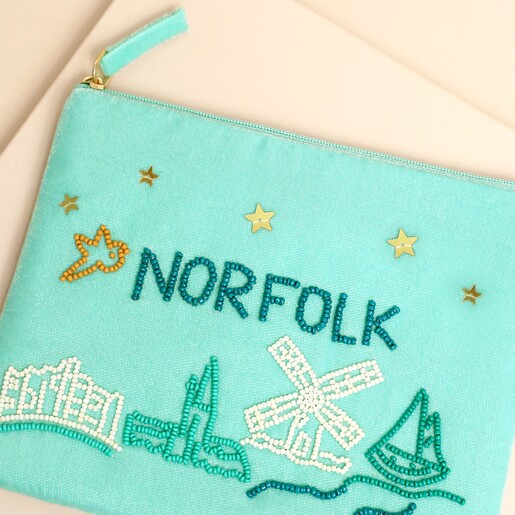 Close-up of beaded Norfolk lettering and coastal motifs on light blue velvet