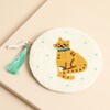 White circular beaded coin purse featuring a ginger tabby cat motif and turquoise tassel