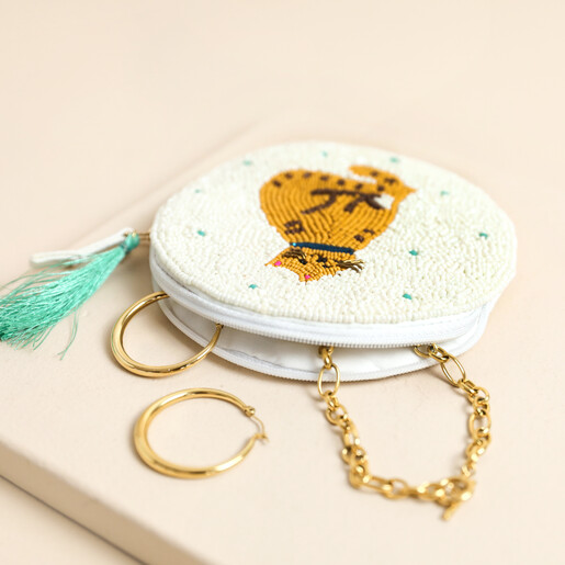 Open beaded cat purse revealing gold hoop earrings and chain necklace inside