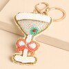 Close-up of beaded martini glass charm with olive detail and crystal bow