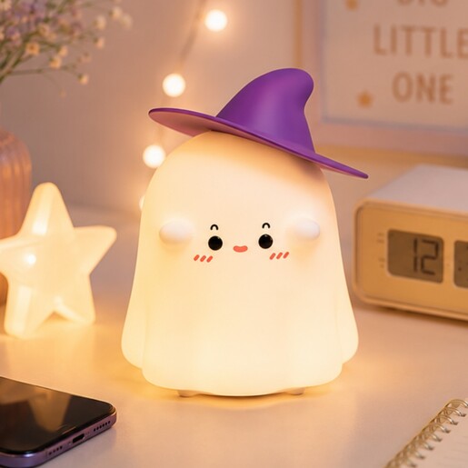 Illuminated ghost nightlight emitting a soft warm glow on a bedside table