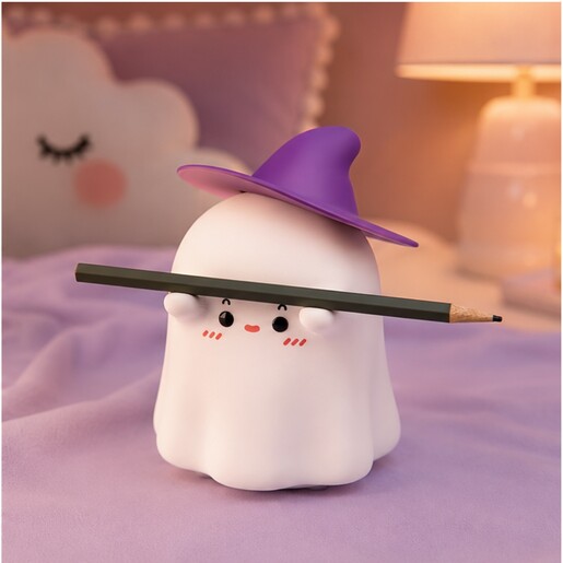 Lila-Boo ghost nightlight holding a pencil in a cosy bedroom setting